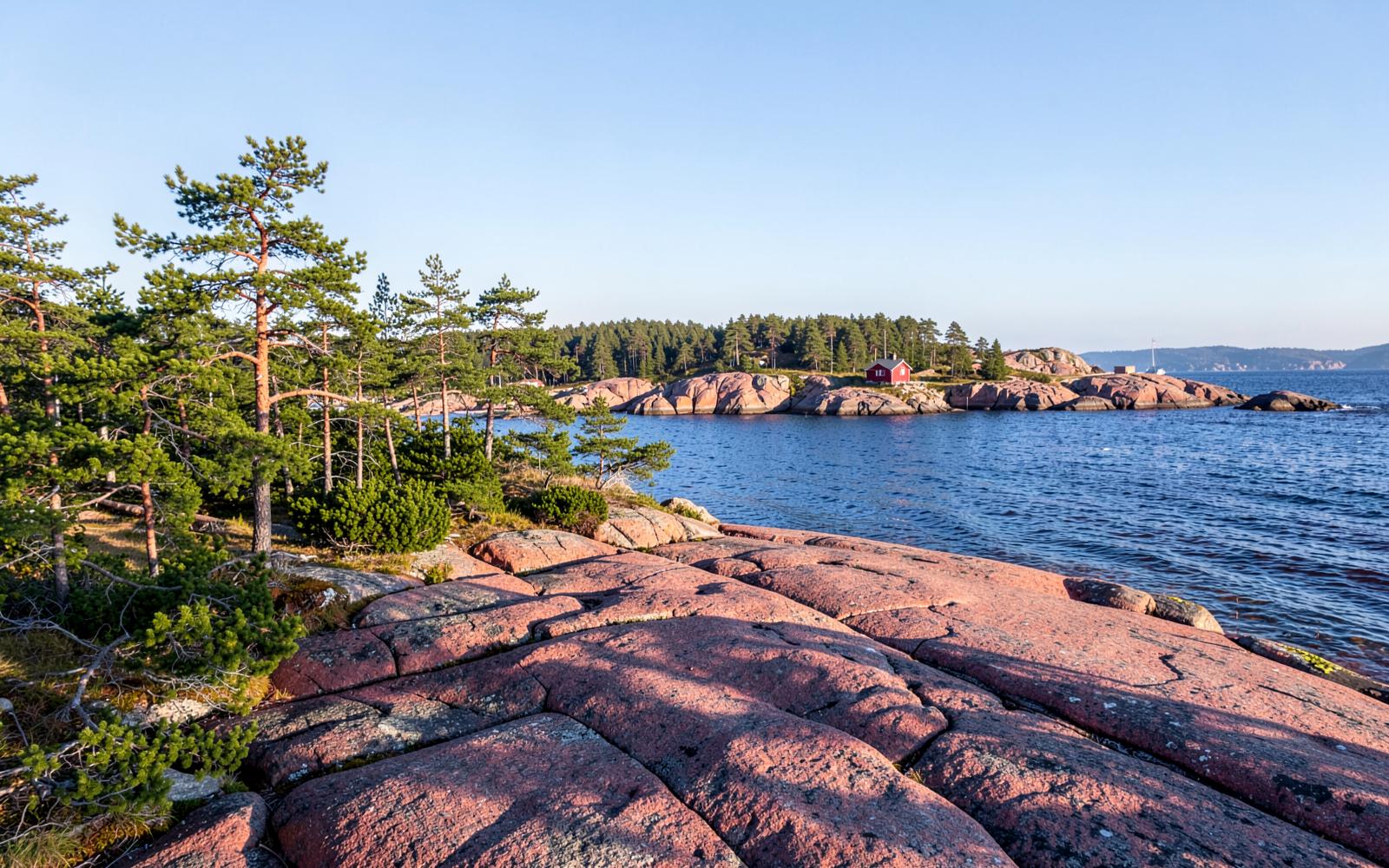 Red granite shoreline and pines on a private island coastline in Aland, Finland