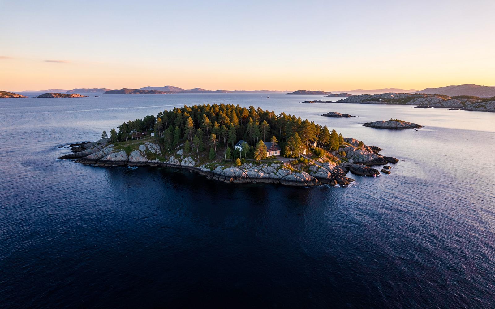 Nordic private island for sale with rocky shoreline and pine forest at sunset in Scandinavia